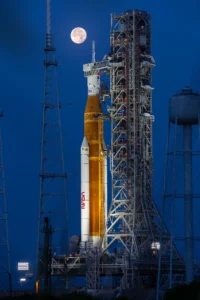 Orange and white space rocket on launchpad.
