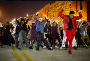 Halloween costumed dancers performing on night city street